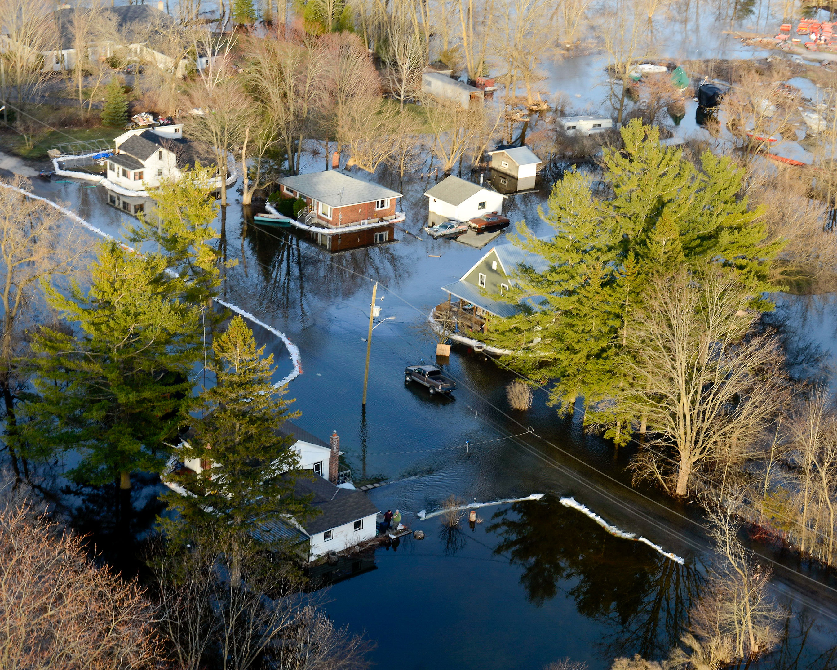 Aerial view of a residential area experiencing flooding with several homes surrounded by water.