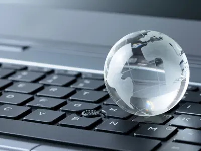 Crystal globe resting on a laptop keyboard.